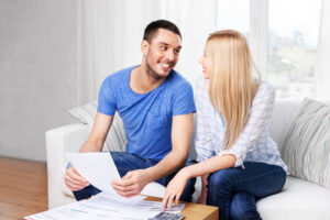 couple with paper bills and calculator at home