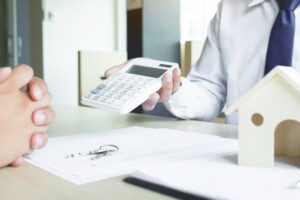 Real estate agent showing the purchase price on a calculator to a client.