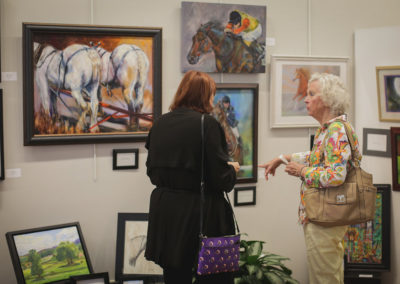 Women looking at artwork at the Hometown Derby Connections Exhibit