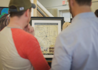 Men looking at artwork at the Hometown Derby Connections Exhibit