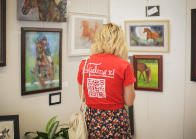 Woman looking at paintings at the Hometown Derby Connections.