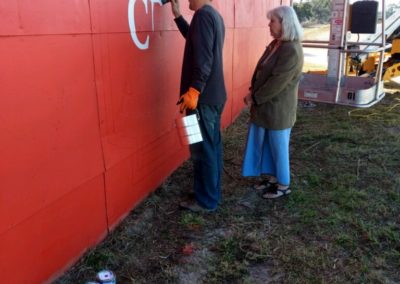 A person painting a barn