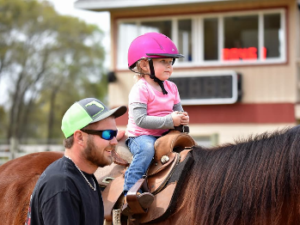 A toddler riding a horse