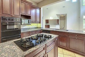 A handsome kitchen with granite countertops.
