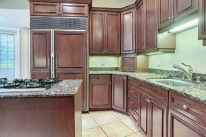 A kitchen with wood cabinets and granite counters.