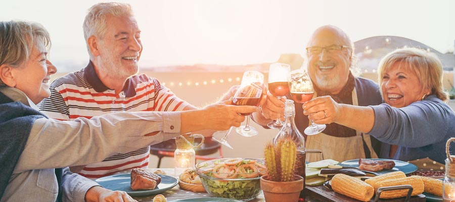 Retirees enjoying a sunset dinner with wine and friends.