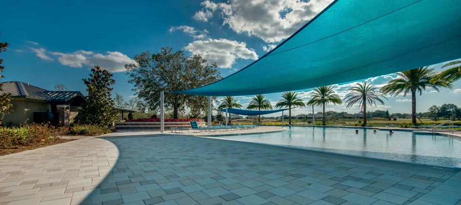 A stylish, pristine pool with awning sun shield providing shaded areas.