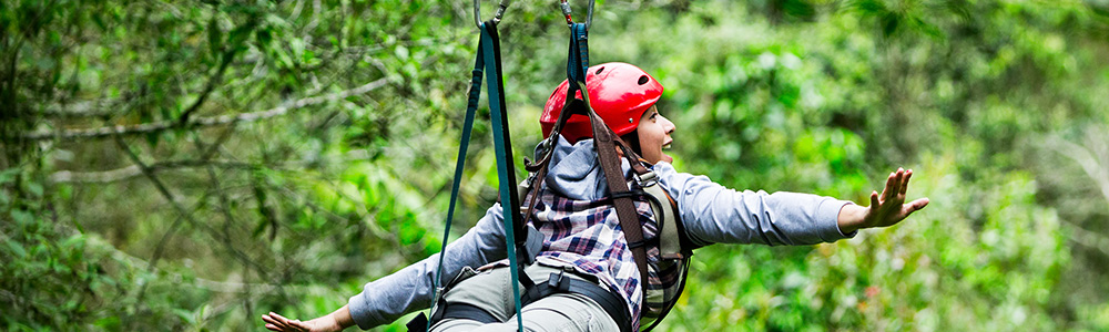 A zipliner soaring through the treetops