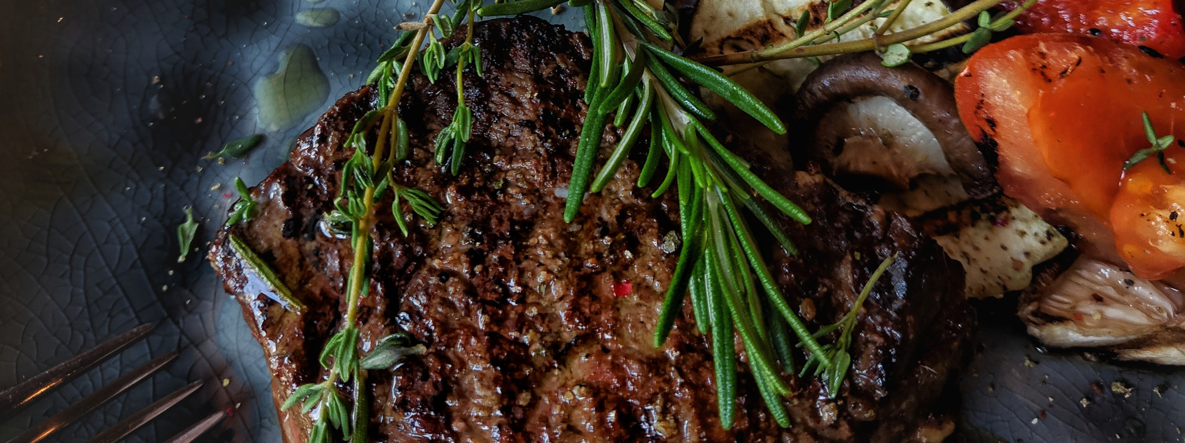 Steak with rosemary and sauteed vegetables.