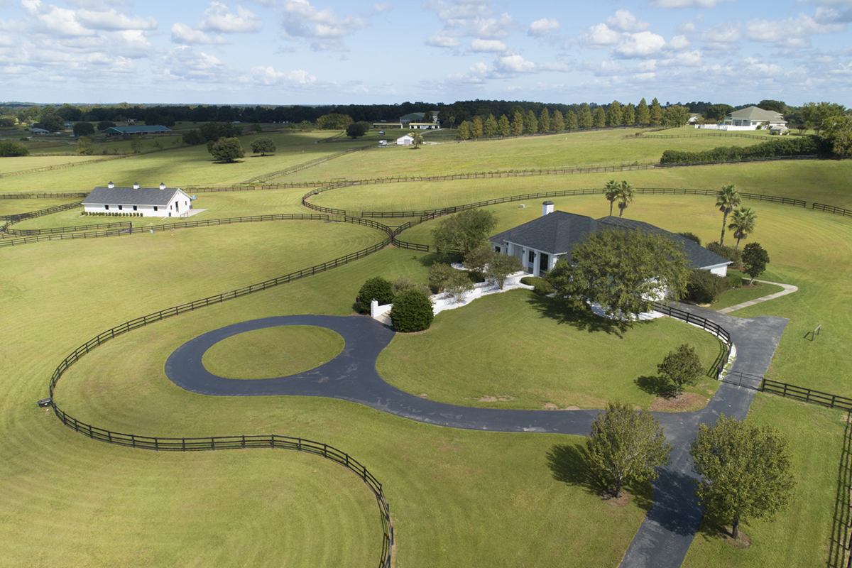 A aerial view of a stunning horse farm resting on a hill.