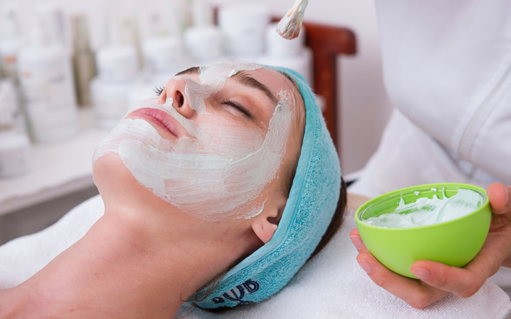A woman getting a facial at a spa.