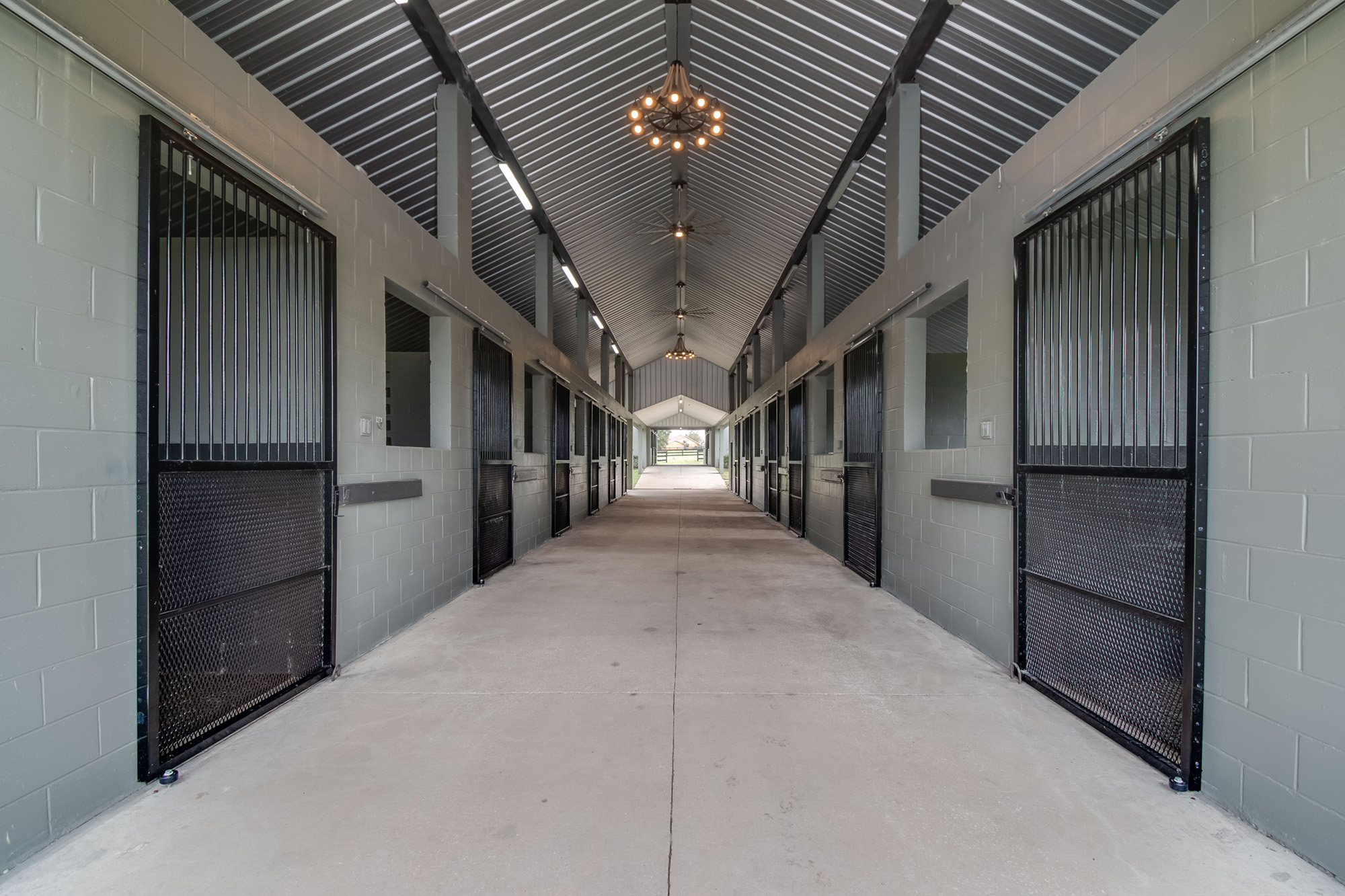 The center aisle of a beautiful barn at a horse farm.