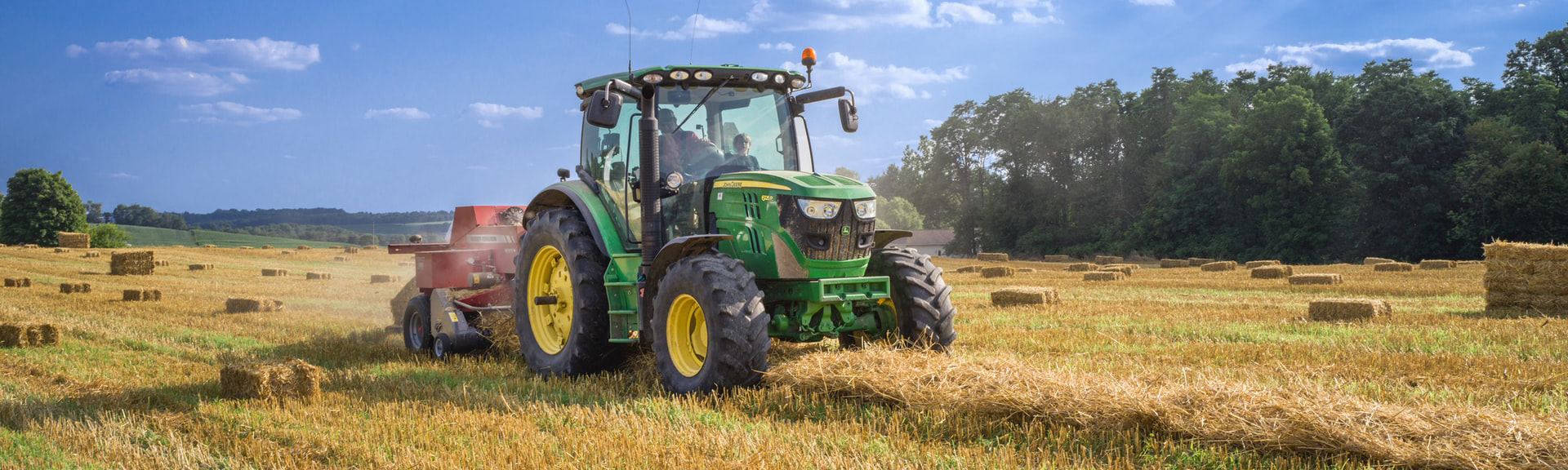 A tractor working on bales of hay.