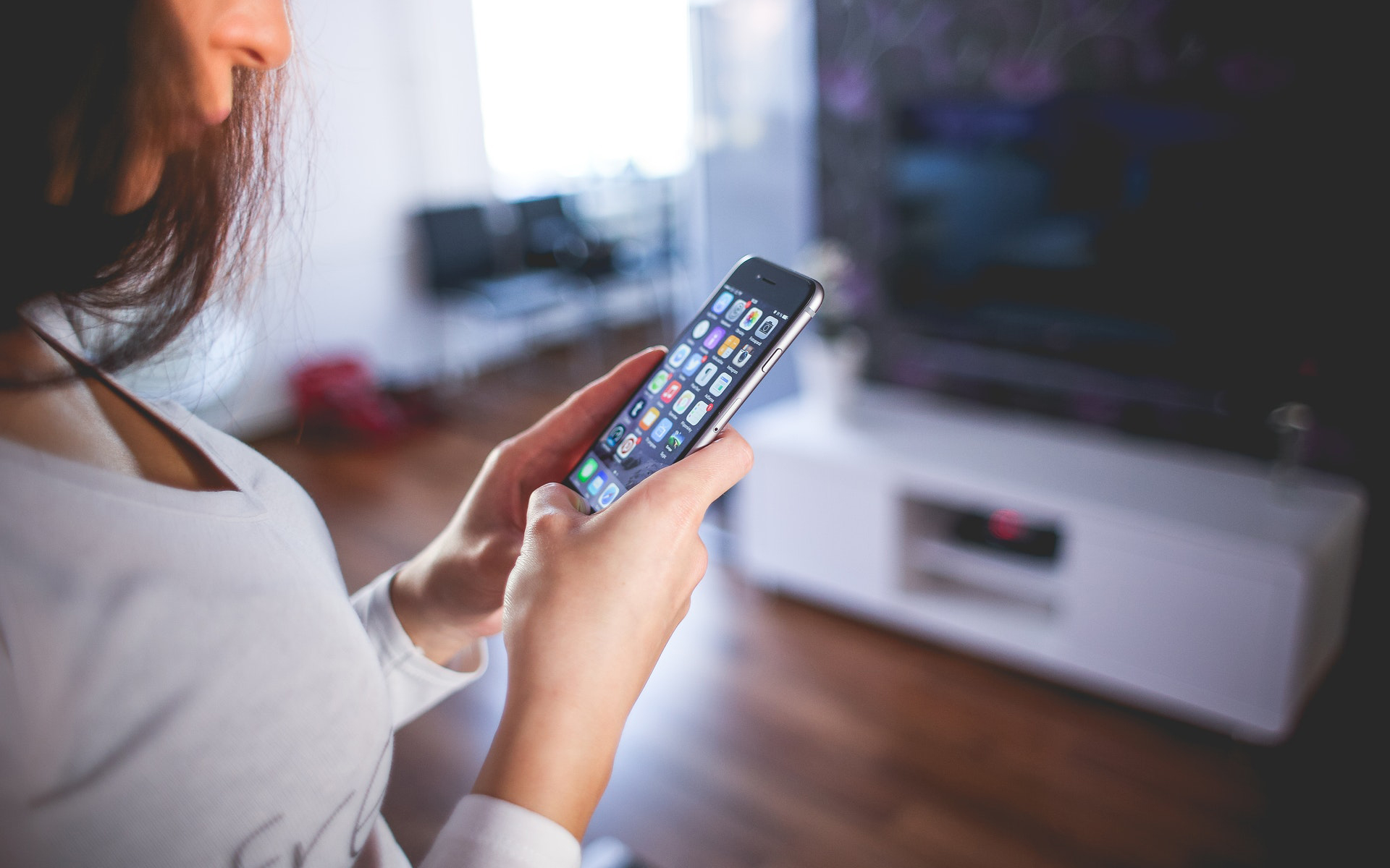 A woman using her cell phone to control features of her home.