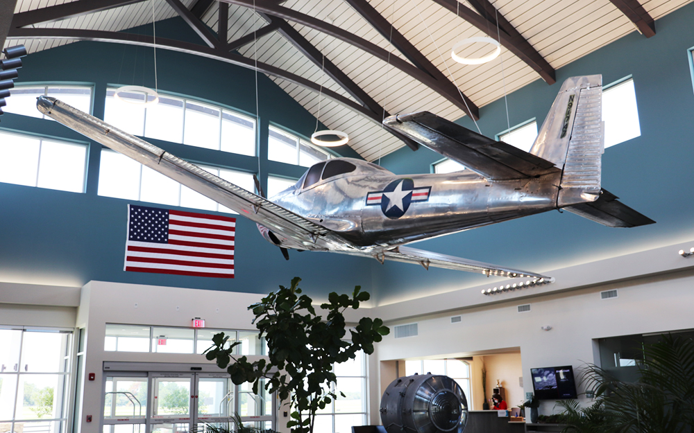 Soaring over the room, as if in mid-flight, is an almost pristine 1947 North American Navion suspended from the ceiling directly above a huge, original signal beacon from when the airport was first built. 