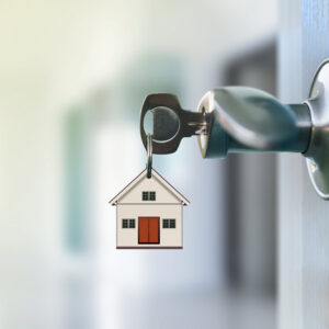 A house key chain in the lock of the door.