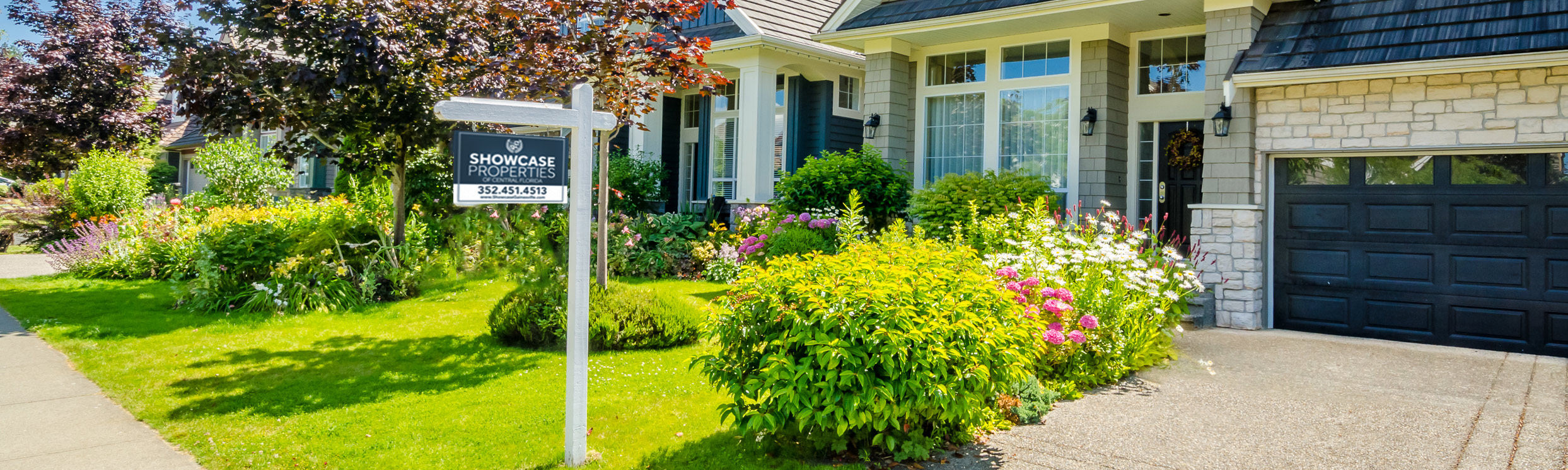 A beautiful home with a "For Sale" sign.