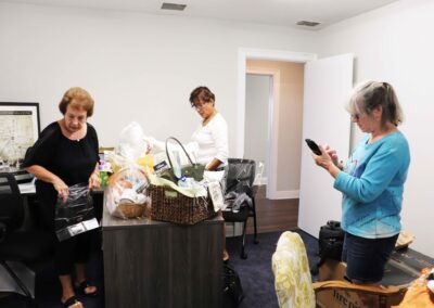 Linda Adamson, Jody Micilcavage, and Noris N Roche assembling gift baskets for the event.