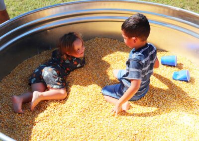 Children having a great time in the pit of corn at the Fall Festival 2021