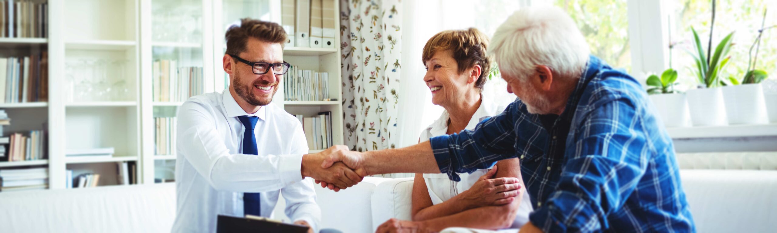 A real estate agent shaking hands with his clients.