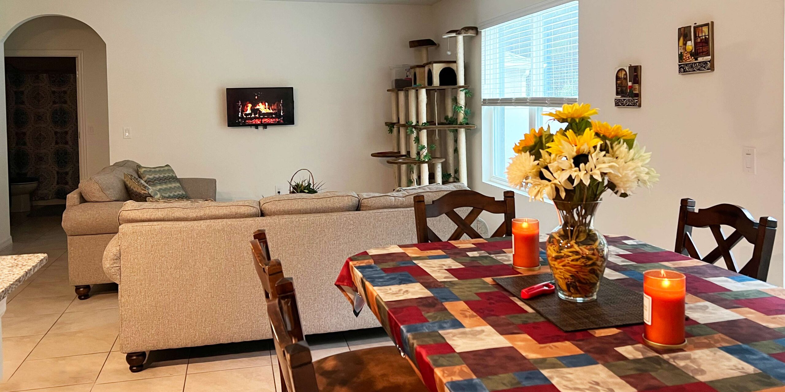 Candles burning warmly on the dining table, the home looks welcoming.