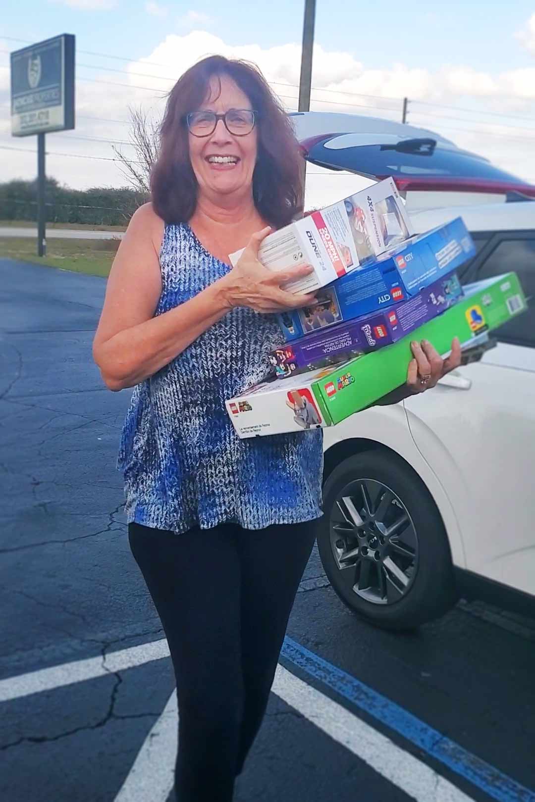 REALTOR® Roxanne Free with her arms full of gifts for the event.