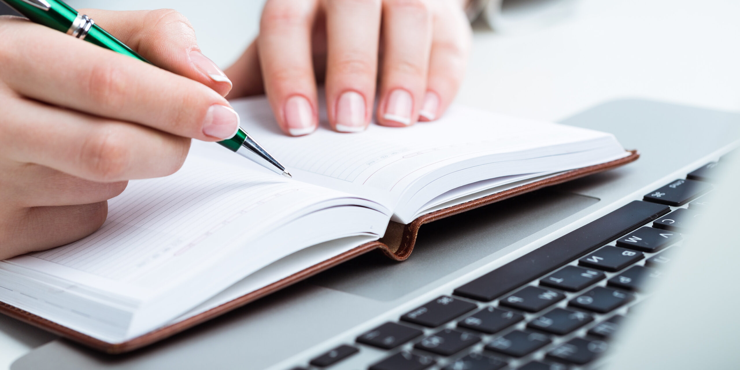 A woman making a list while researching.