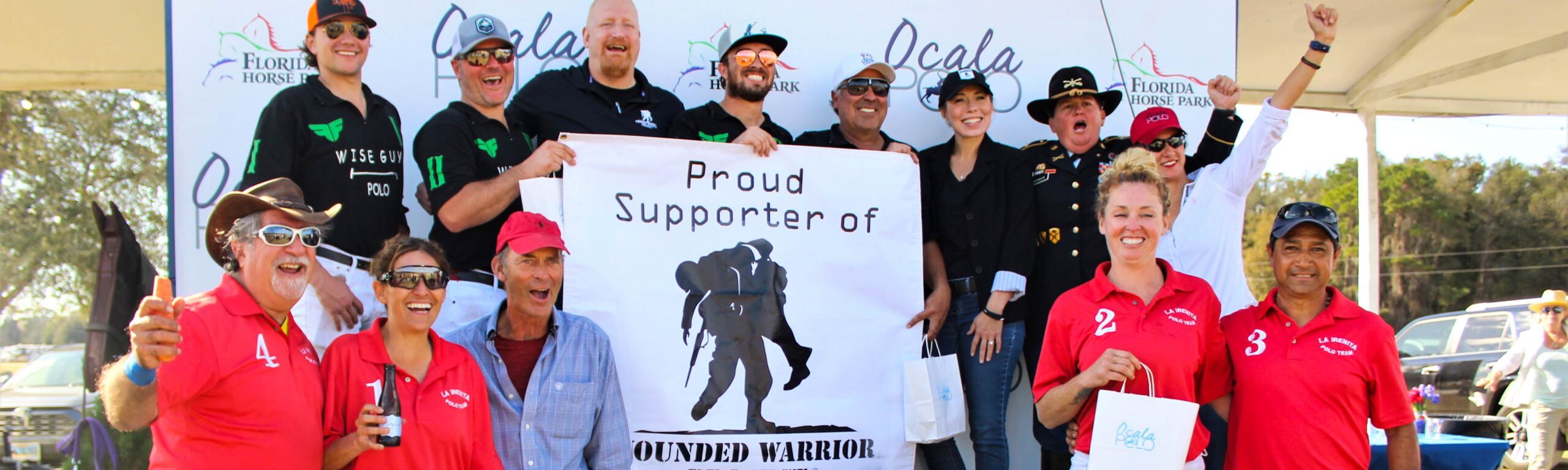 Ocala Polo polo players posing with a Wounded Warriors banner after a match.