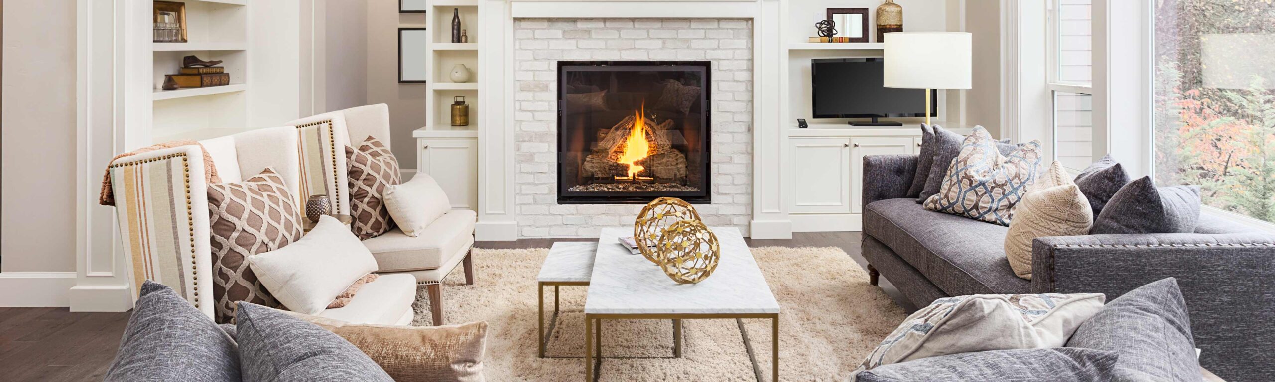 A beautiful neutral living room with crackling fireplace.