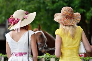 Two ladies in hats ready for the race.