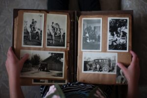 A person looks through an album of vintage photographs. 
