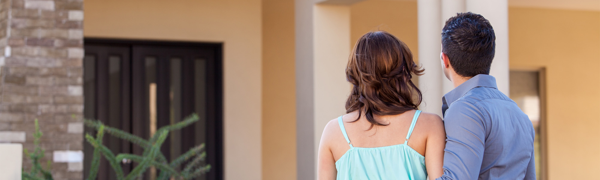 Young couple looking at the front door of a house