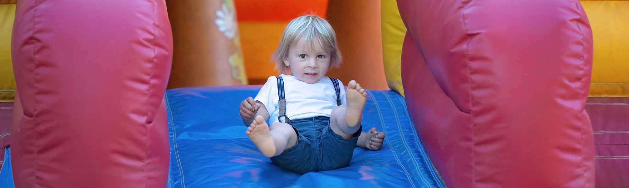 A child sliding on an inflatable slide.