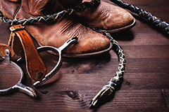 Cowboy boots,whip and spurs on wood