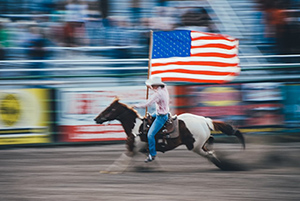 Rodeo rider on a horse with American flag