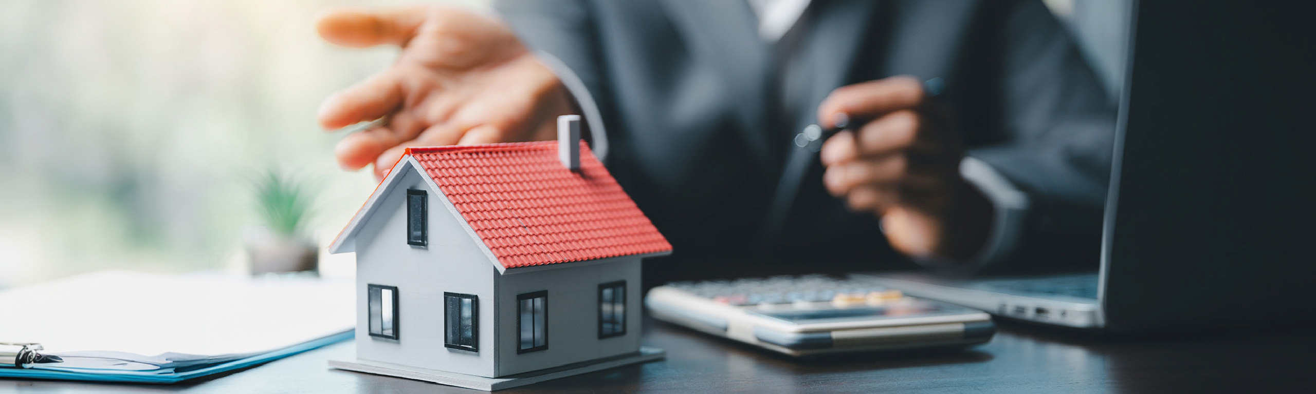 Close up of a miniature house and calculator