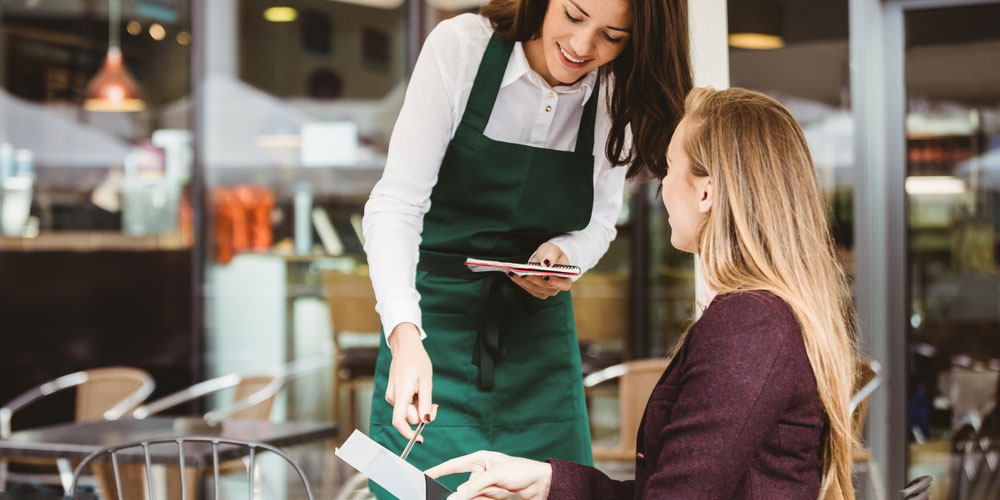 A server helps a customer with their order.