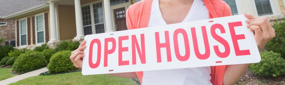 A REALTOR® holding a sign for an Open House